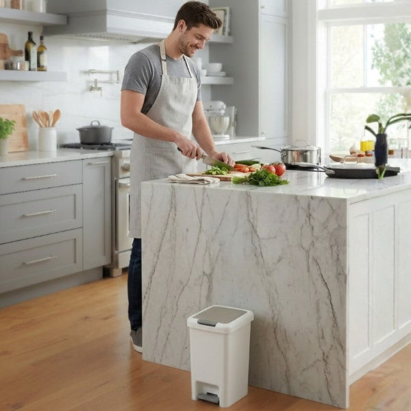 Homme cuisinant sur ilot pres poubelle de cuisine