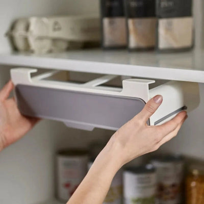 Personne qui installe l'epices rangement sous une étagère