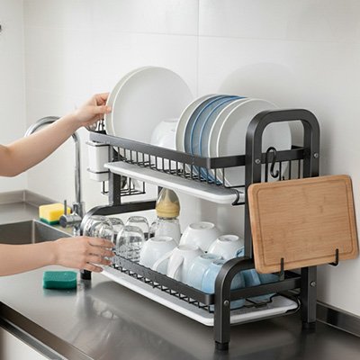 Personne déposant assiette dans égouttoir à vaisselle