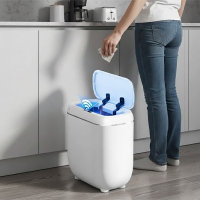 Personne deposant dechets dans poubelles de cuisine ouverture automatique