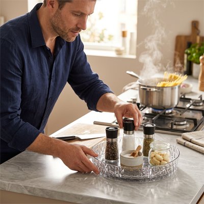 Personne prenant une contenant de sel dans range epice transparent