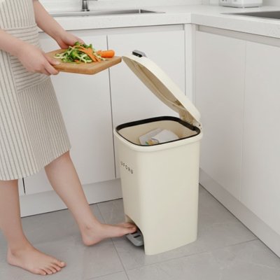Personne vidant épluchures dans poubelle cuisine 